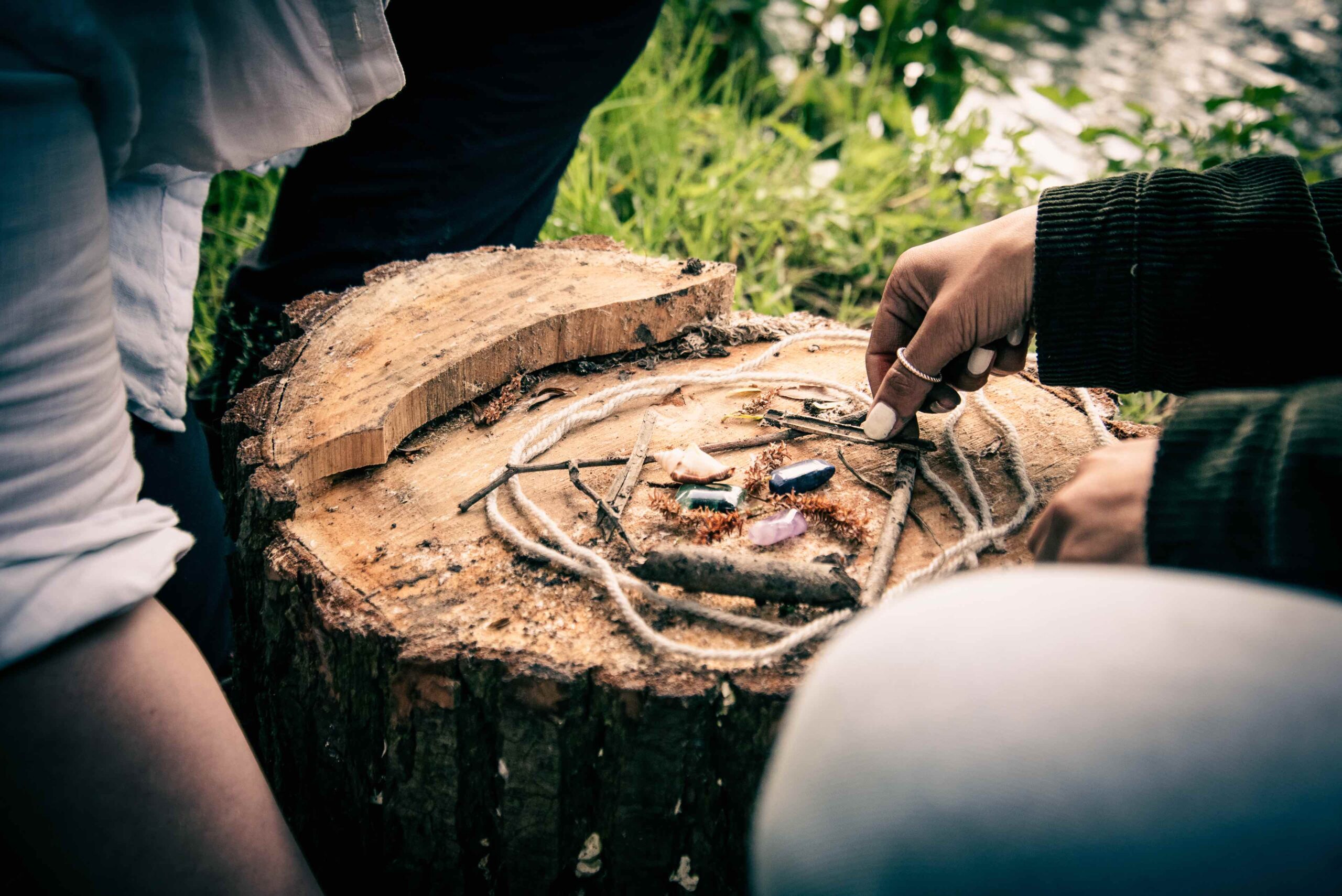 Outdoor Arts Psychotherapist using string and crystals to connect their client to nature.