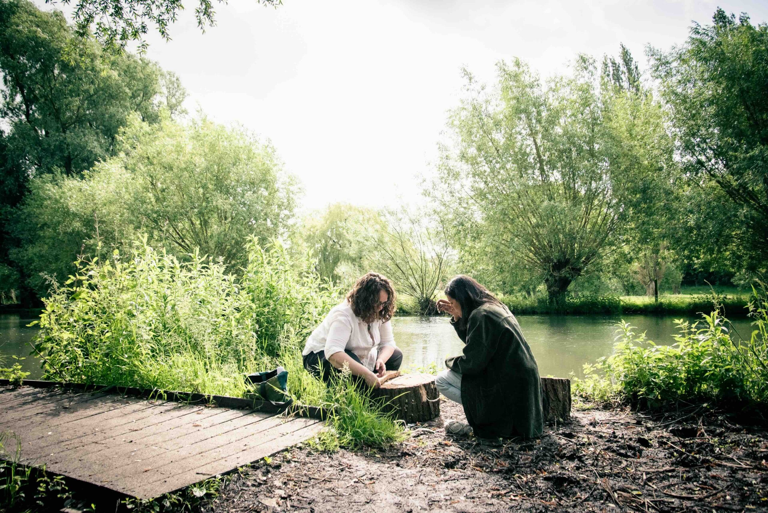 Annabell-Webb-Outdoor-Eco-Therapy Two women making footprints in the mud during an Outdoor Arts Psychotherapy session.